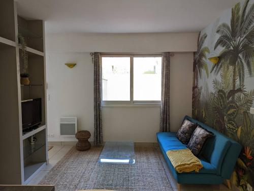 sala de estar con sofá azul y ventana en Appartement hyper central et calme, à 5 mètres de Monaco, en Beausoleil