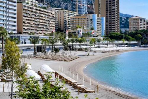 uma praia com espreguiçadeiras e o oceano em Appartement hyper central et calme, à 5 mètres de Monaco em Beausoleil