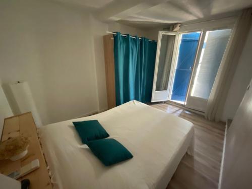 - une chambre avec un lit blanc et un oreiller vert dans l'établissement Le Cocon des SPRESS, à Cers