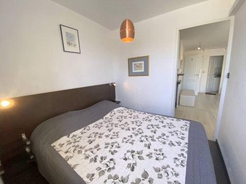 une chambre avec un lit avec une couverture dessus dans l'établissement Appart 451, Port Soleil au village naturiste, au Cap d'Agde