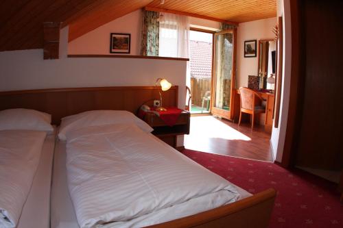 ein Schlafzimmer mit einem Bett und ein Zimmer mit einem Schreibtisch in der Unterkunft Landhotel Waldmühle in Sankt Georgen im Attergau