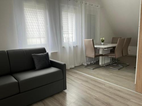 sala de estar con sofá, mesa y sillas en Ferienwohnung Soltau, en Soltau