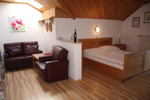 ザンクト・ゲオルゲン・イム・アッターガウにあるLandhotel Waldmühleのベッドルーム1室(ベッド1台、ソファ、椅子付)