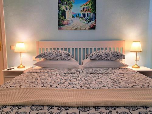 a bedroom with a large bed with two lamps at Las Teresitas Apartment in San Andrés