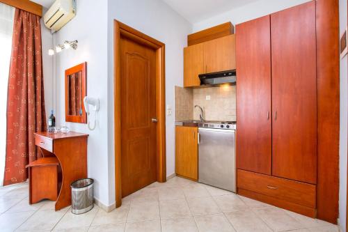 een kleine keuken met houten kasten en een wastafel bij Studios Maria in Potos