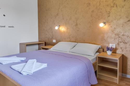 1 cama con sábanas blancas y almohadas en una habitación en Apartments Patar, en Grabovac