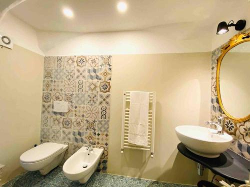 a bathroom with a sink and a toilet and a mirror at Nel cuore di Genova in Genova