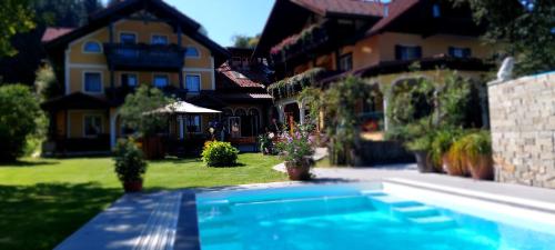 a house with a swimming pool in front of a house at Landhotel Waldmühle in Sankt Georgen im Attergau