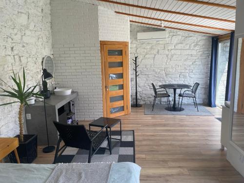 um quarto com uma mesa e cadeiras e uma parede de tijolos em Tatsopus em Kamianets-Podilskyi