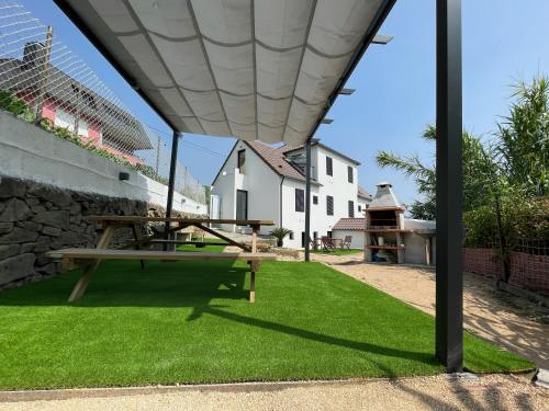un tavolo da picnic sotto una tenda da sole in un cortile di Casa Cuartel a Redondela