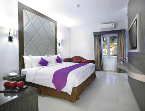 Tempat tidur dalam kamar di Quest Hotel Balikpapan by ASTON