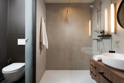 een badkamer met een wastafel, een toilet en een spiegel bij master Linzergasse in Salzburg