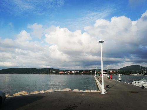 a dock on a body of water with a cloudy sky at Arija in Bilice
