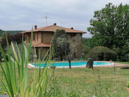 a house with a swimming pool in front of it at Il Colombaiolo in Castelmuzio