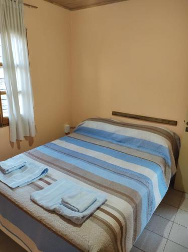 a bedroom with a bed with towels on it at Departamento Payún Matrú in Malargüe