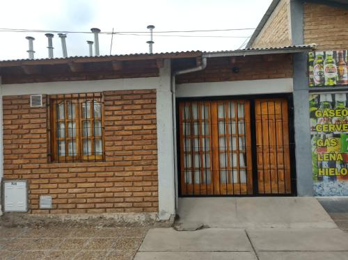 un edificio de ladrillo con dos puertas y un cartel en él en Departamento Payún Matrú, en Malargüe