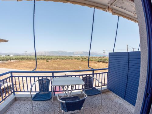 a balcony with a table and chairs on it at Pavlopetri in Vingláfia