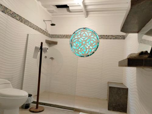 a bathroom with a toilet and a plate on the wall at Tambo Marina Eco Hostal in Piojó
