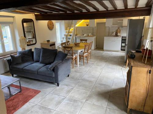 a living room with a blue couch and a table at Maison de Charme 4 chambres in Les Moutiers-en-Cinglais