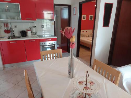 una cocina con una mesa con un jarrón de flores. en Apartments Sunčica, en Mali Lošinj