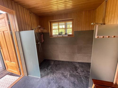 a small bathroom with a refrigerator and a window at Arukalda Puhketalu 