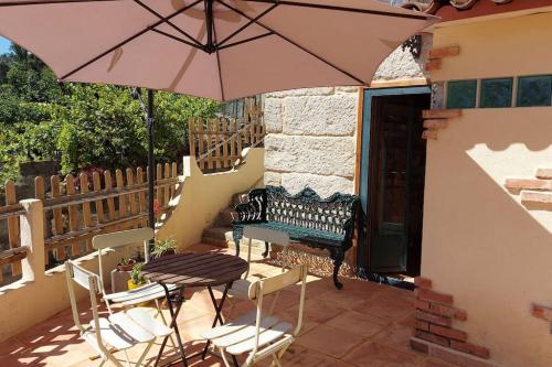 a patio with a table and chairs and an umbrella at Sweet Stone in Vigo