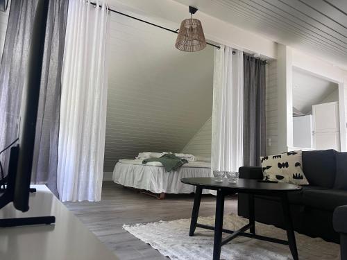 een woonkamer met een bank, een tafel en een bed bij Medvik Högalid in Strömstad