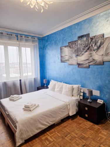 um quarto com uma cama grande e paredes azuis em Torino Panoramic view Apartment em Turim