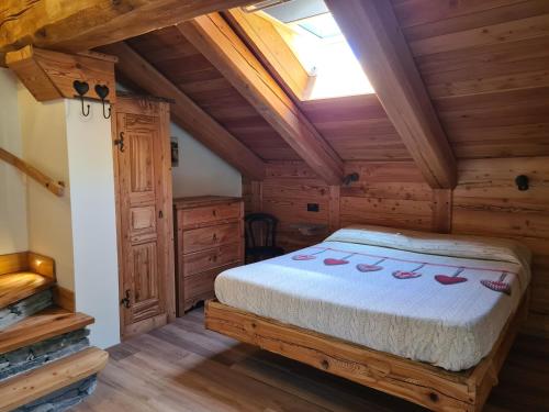 ein Schlafzimmer in einem Blockhaus mit einem Bett in der Unterkunft La Maison. Il Nido dell'Aquila in Bardonecchia