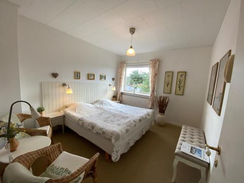 1 dormitorio con 1 cama, mesa y sillas en Klithjem Badehotel en Vejers Strand