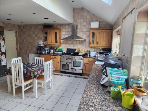 a kitchen with a table and chairs and a stove at Countryside Home in London in Shirley