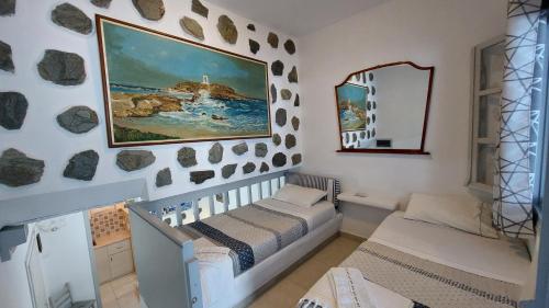 une chambre avec un lit bébé et un tableau mural dans l'établissement Azzurro Naxos, Azzurro I - Azzurro II - Azzurro III, à Naxos Chora