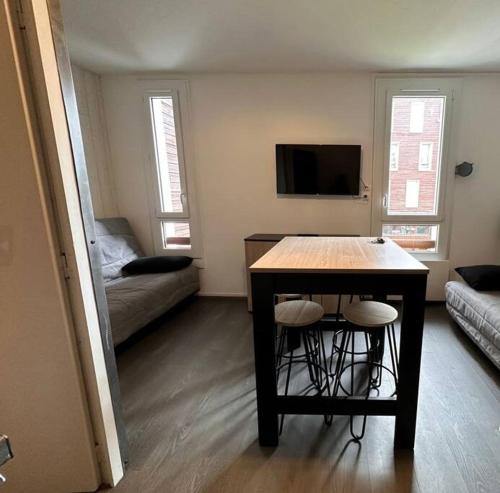 - un salon avec une table et deux tabourets dans l'établissement Studio Guzet-Neige, au pied des pistes, à Ustou