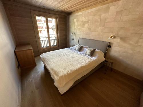 a bedroom with a large bed with a window at Appartement de luxe, parking sous-terrain, centre-ville Auron in Auron