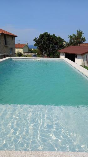a large pool of blue water in front of a house at Harrisko etxea in Viana do Castelo