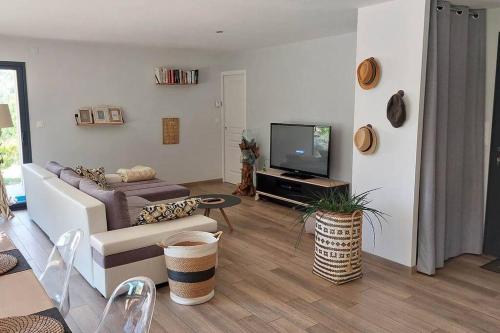 ein Wohnzimmer mit einem Sofa und einem TV in der Unterkunft chez Rod in Cajarc