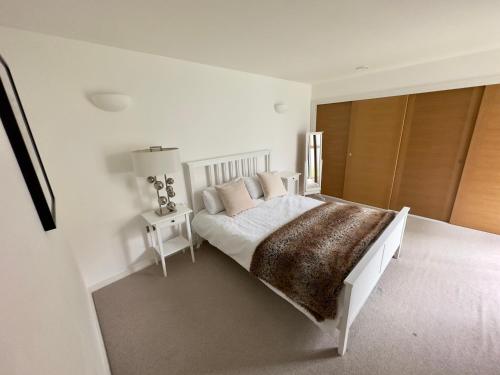 sypialnia z białym łóżkiem i brązowym kocem w obiekcie Central London Luxury 4 Bed Home w Londynie