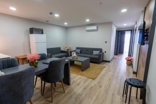 a living room with a couch and a table and chairs at Yusufhan Suites in Trabzon