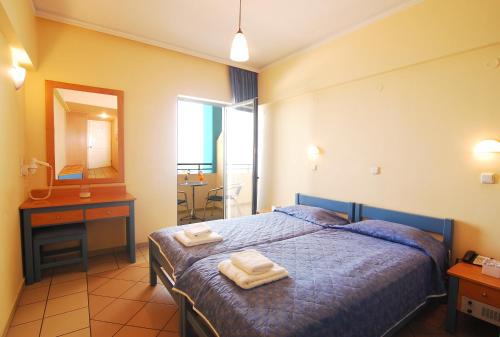 a bedroom with a bed with two towels on it at Medusa Apartments in Rethymno Town