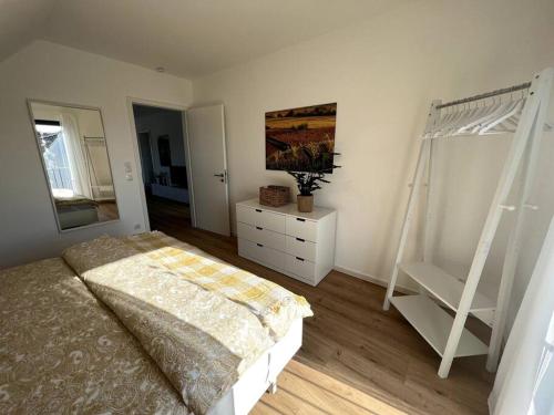 een slaapkamer met een bed en een dressoir bij Rückzugsort im Rebenmeer mit Grill & Parkplatz in Venningen