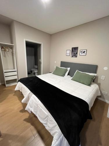 1 dormitorio con 1 cama blanca grande con almohadas verdes en 6A Monoambiente capital, amplio, luminoso y acogedor en Buenos Aires