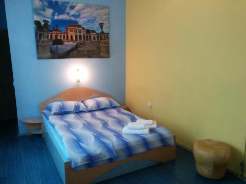 a bedroom with a bed with a painting on the wall at Pensiunea Casa Raul in Cluj-Napoca