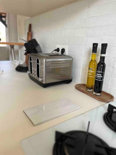 un comptoir de cuisine avec un grille-pain et deux bouteilles de vin dans l'établissement Duplex bord de mer La Madrague, à Marseille