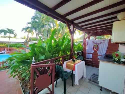 a patio with a table and chairs next to a pool at ISK LOCATION in Sainte-Rose