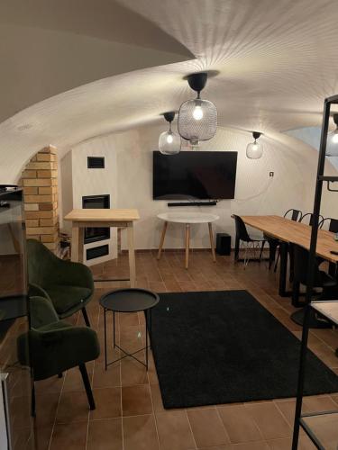 a living room with a table and a tv at Historická vila Dom hostí in Podbrezová