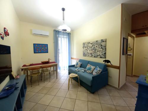 een woonkamer met een blauwe bank en een tafel bij Pozzuoli 100per100 Home in Pozzuoli