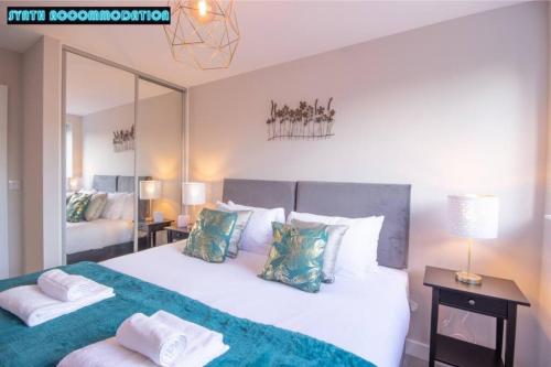 sypialnia z dużym białym łóżkiem z poduszkami w obiekcie Free Private Parking Modern 2 Bed Apartment Vine Ct 5 w mieście Dorking