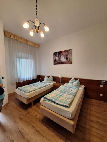 1 Schlafzimmer mit 2 Betten und einem Kronleuchter in der Unterkunft Gaststätte und Pension Zur Schiene in Merseburg