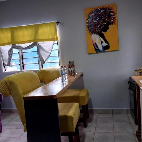 a dining room with a table and a painting on the wall at Bedroom Diani Beach in Galu