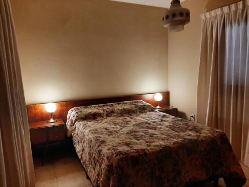 um quarto com uma cama e 2 candeeiros nas mesas em Los Faroles em Salta